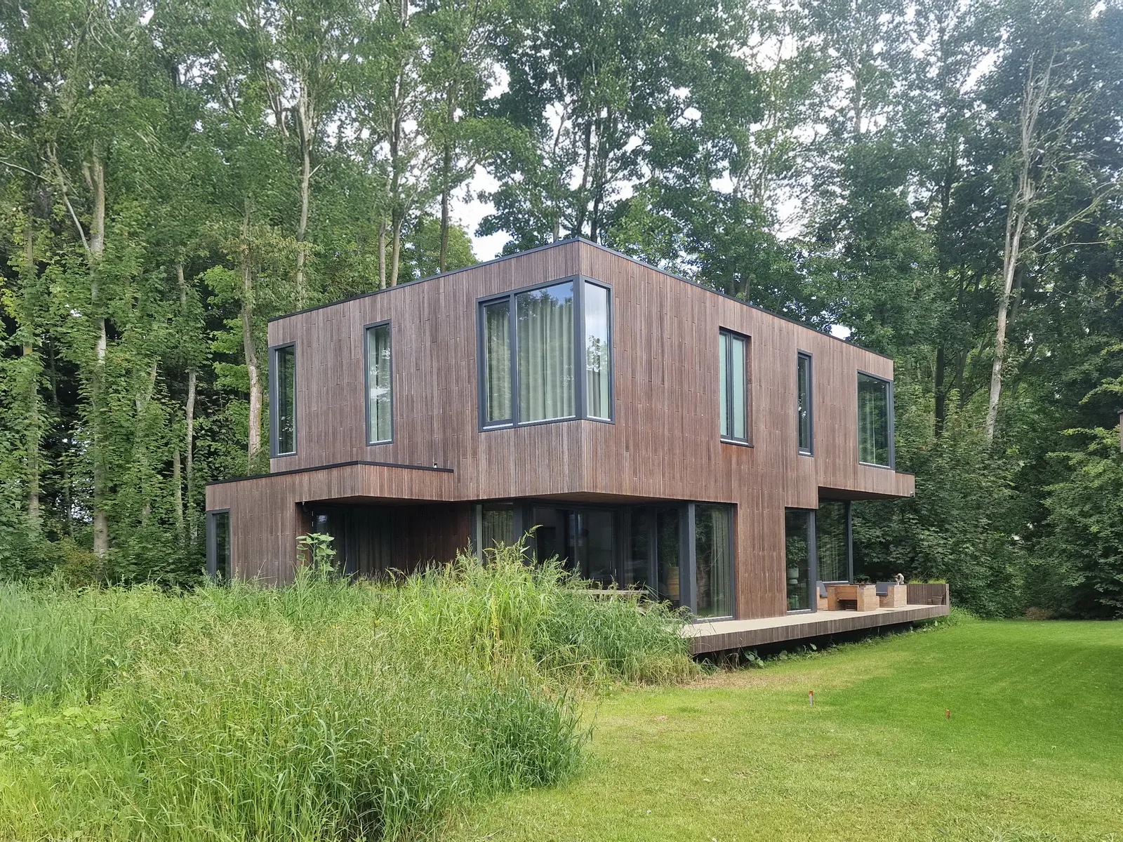 Natuurinclusief villaontwerp met grote glaspartijen en sterke relatie met het Goois landschap