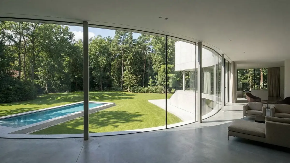 Woonruimte met gebogen lijnen en veel daglicht in een vernieuwde villa in Lelystad