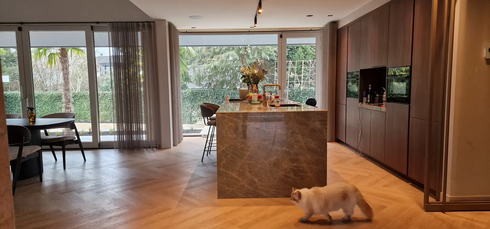 Aanbouw met hoge eetkeuken en veranda - eiken spanten en grote glaspuien met zicht op de tuin