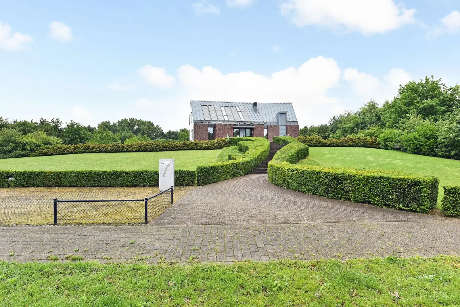 Tuinontwerp vergroot bosrand en creéert privacyzones rondom villa