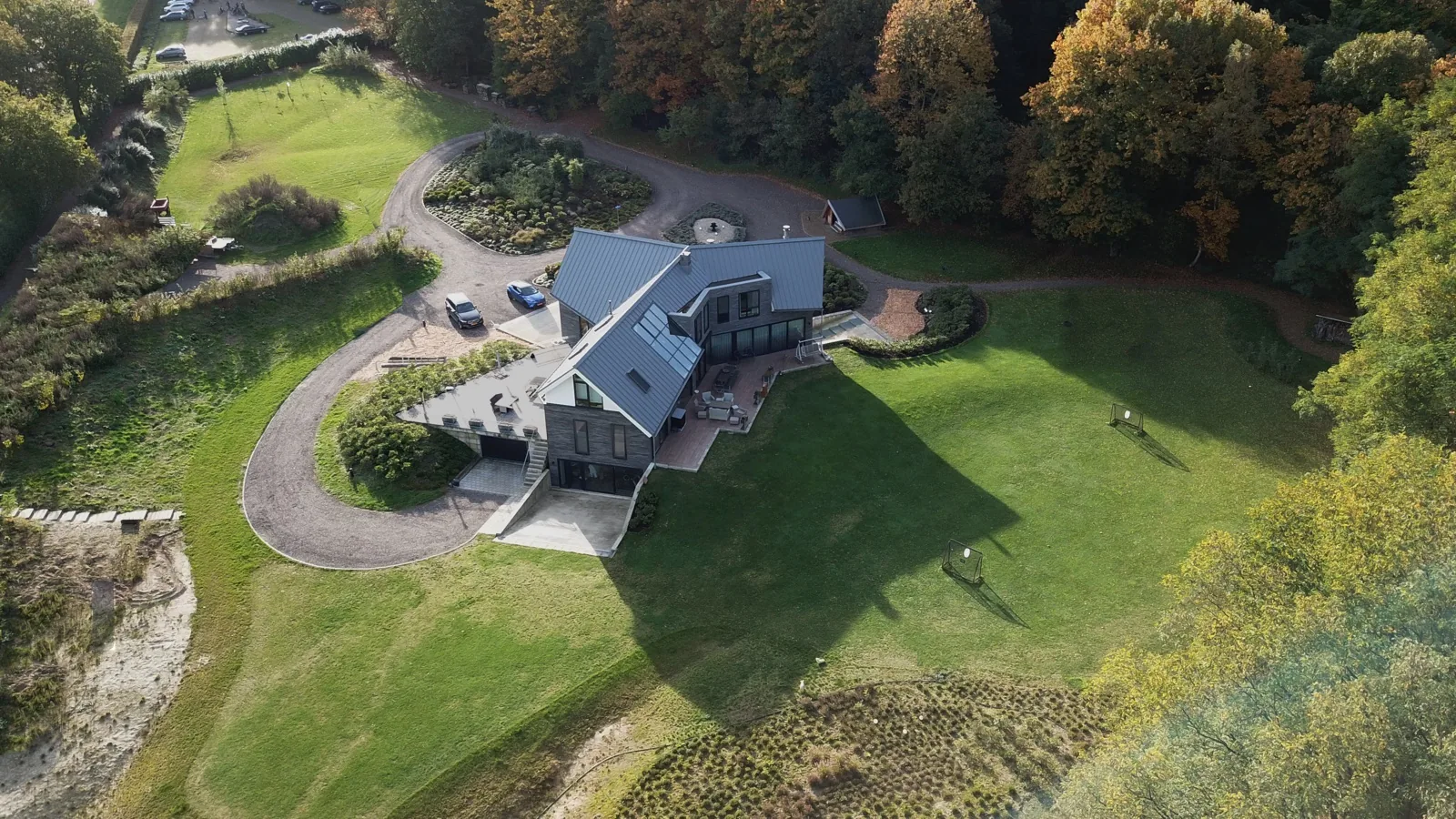 Entree villa Prattenburg met slingerende toegangsweg op driehoekige kavel