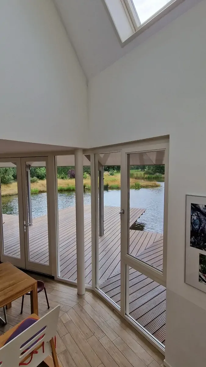 Zicht vanuit de trap op het terras, de zwemvijver en het landschap