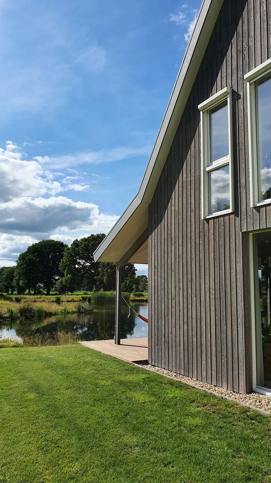 Landhuisgevel met robuust metselwerk en verfijnde details richting de oprijlaan