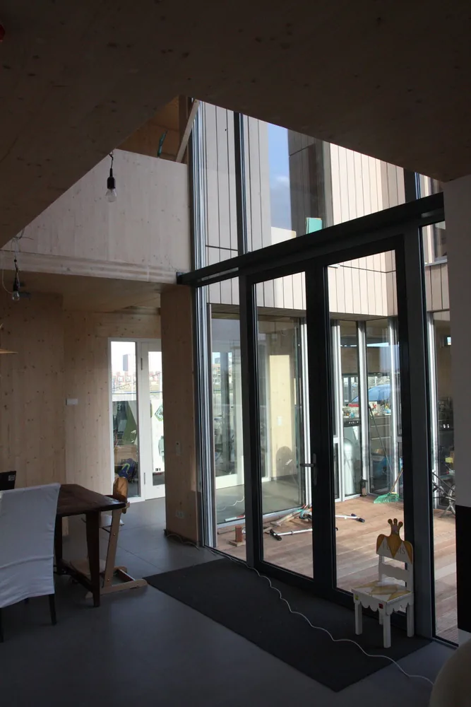 CLT-houten villa op Rieteiland Oost met gesloten straatgevel en openingen naar het water