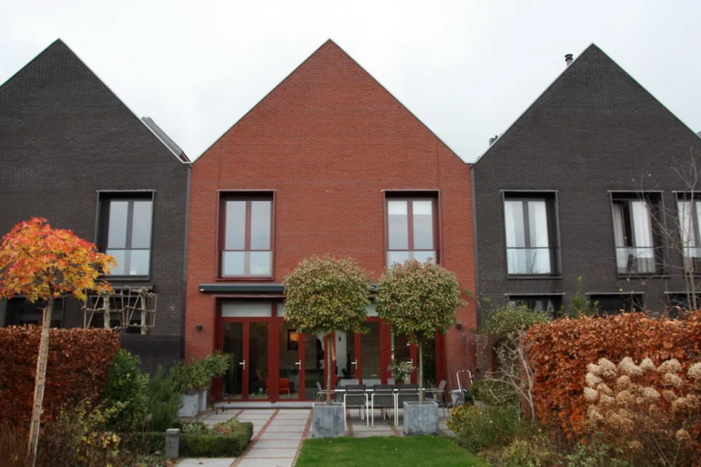 Aanbouw in Cronenburgh met rood aluminium dakvlak dat aansluit op de bestaande architectuur