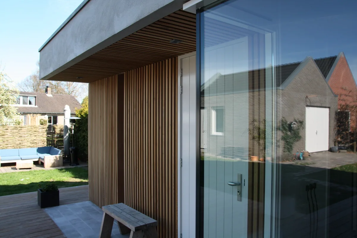 Berging langs de tuinmuur geplaatst om buitenruimte en zichtlijnen vrij te houden