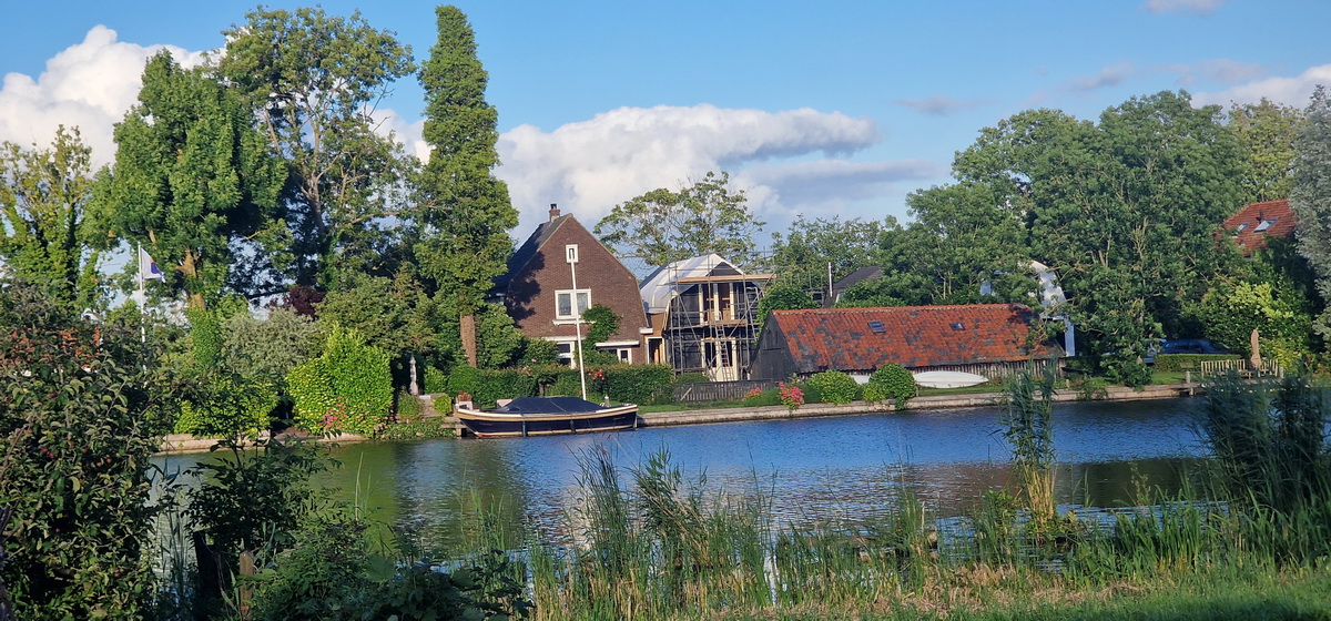 Bijgebouw in aanbouw aan de Vecht in Vreeland met steigerwerk en bestaande woning aan het water