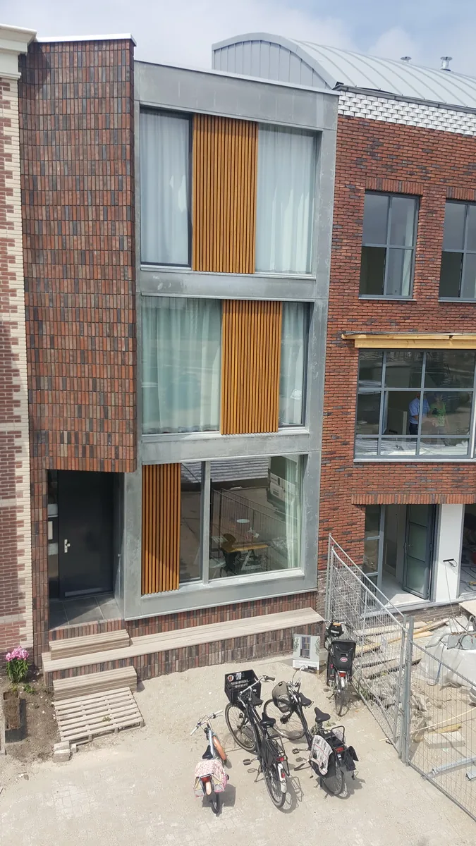 Entreezone met verhoogde plint en geïntegreerde bank in de gevel