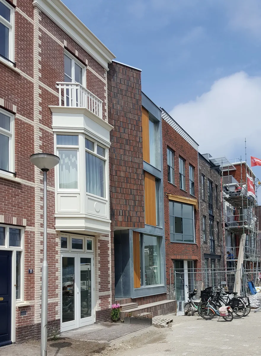 Voorgevel van de stadswoning met verticaal metselwerk en duidelijke entree