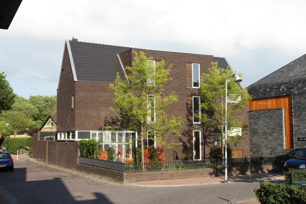 Verdraaide voorgevel van woning als afsluiting van het Jan de Bijerhof