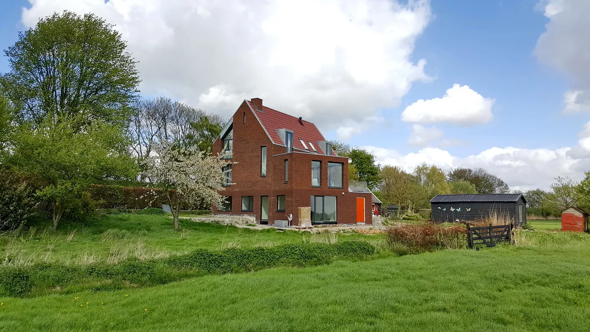 Dijkwoning in Muiden met verhoogde woonlaag en uitzicht op landschap