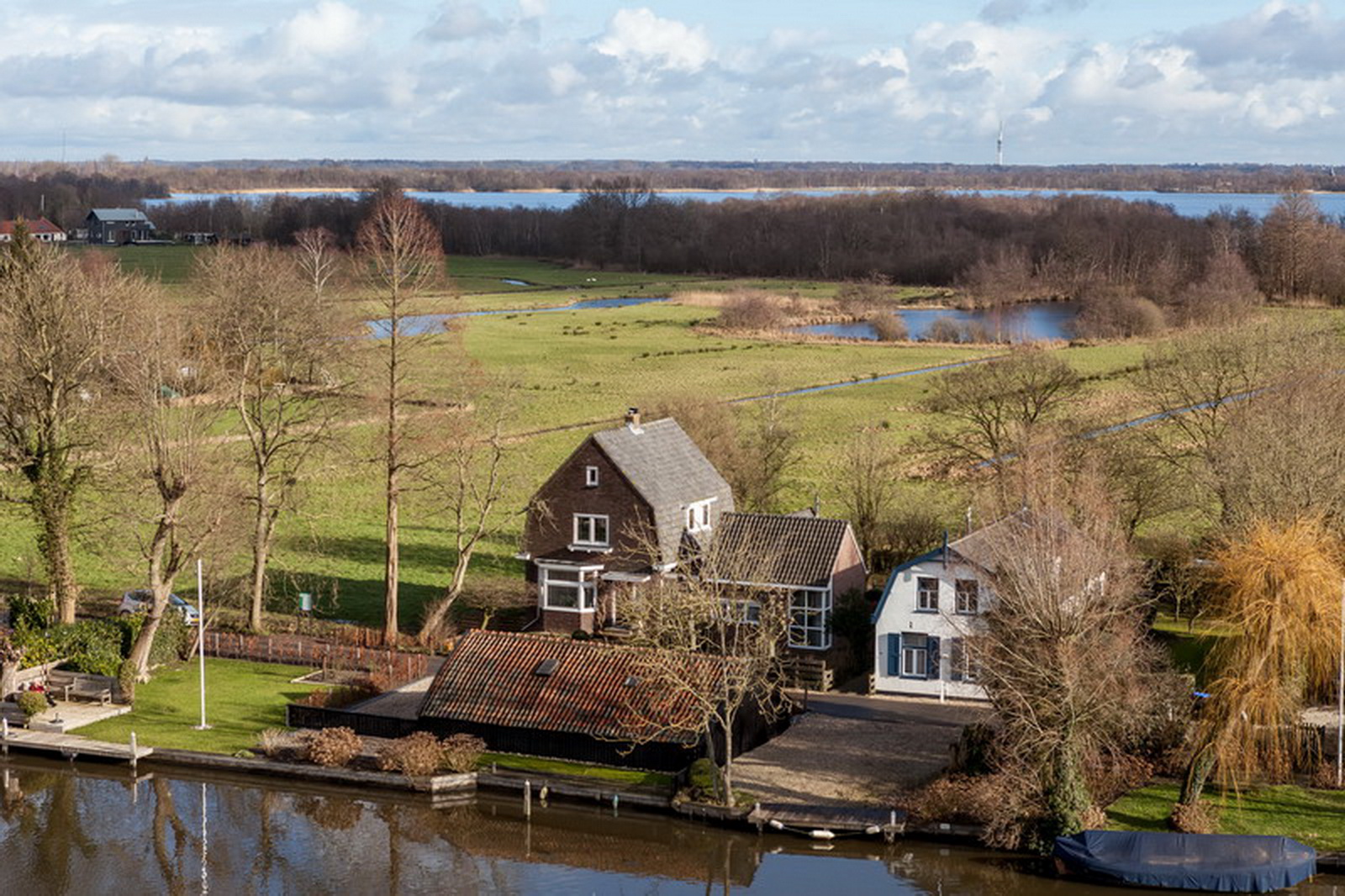 Luchtfoto van woning en bijgebouw aan de Vecht in Vreeland